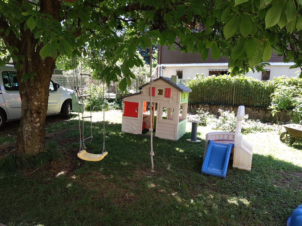 L'espace de jeux et détente devant la maison, à l'ombre du magnolia