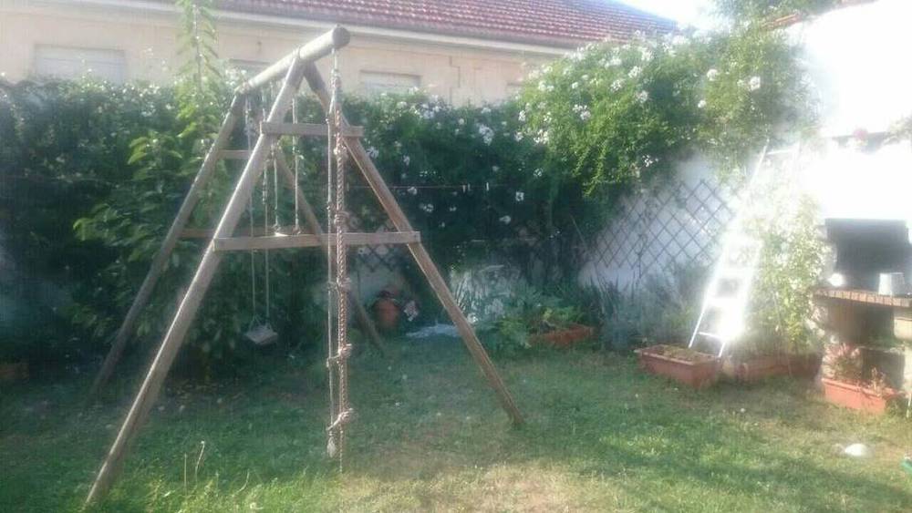 Le jardin avec une balançoire et le barbecue