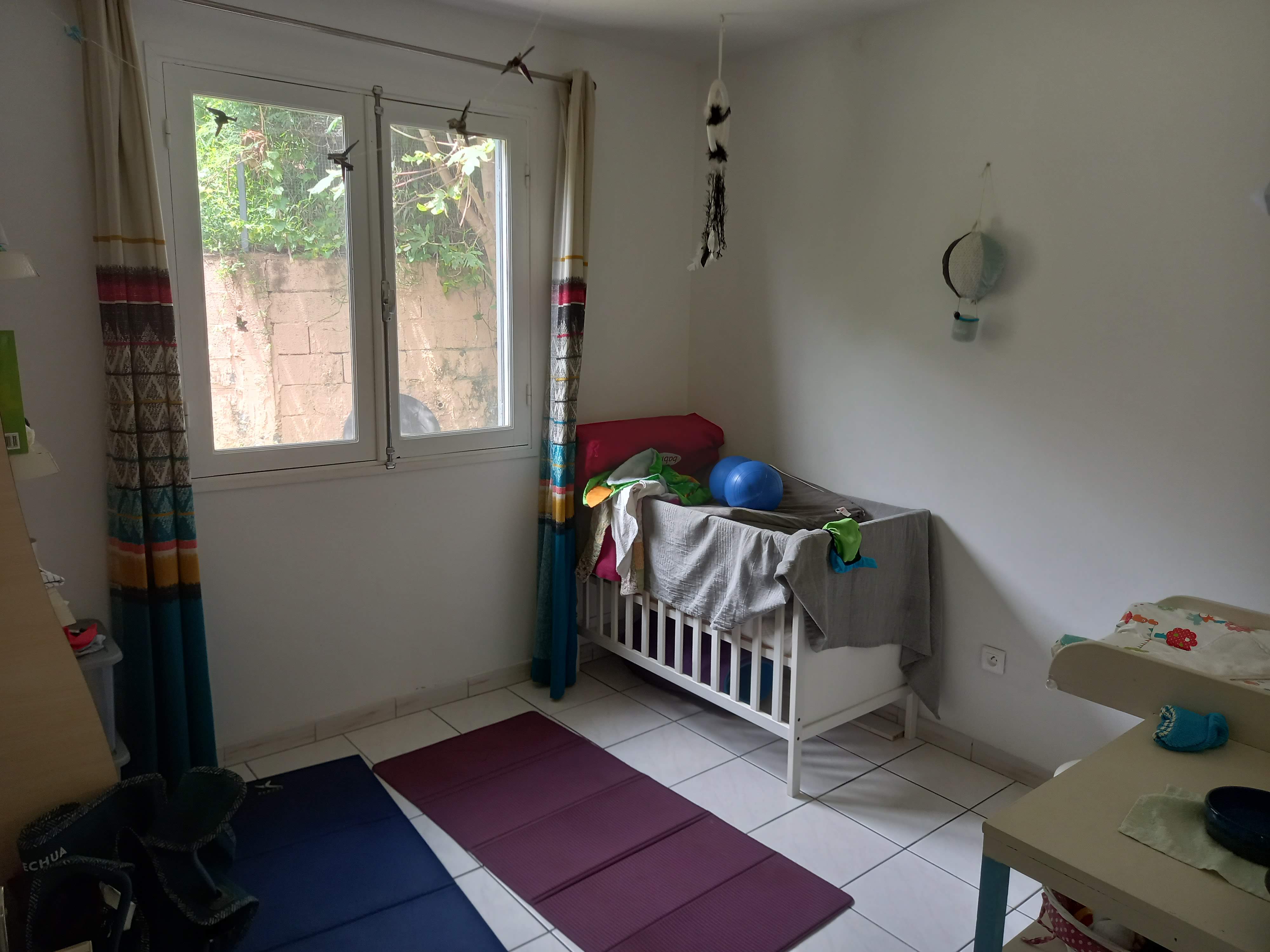Chambre de Jules avec table à langer et tapis de yoga.