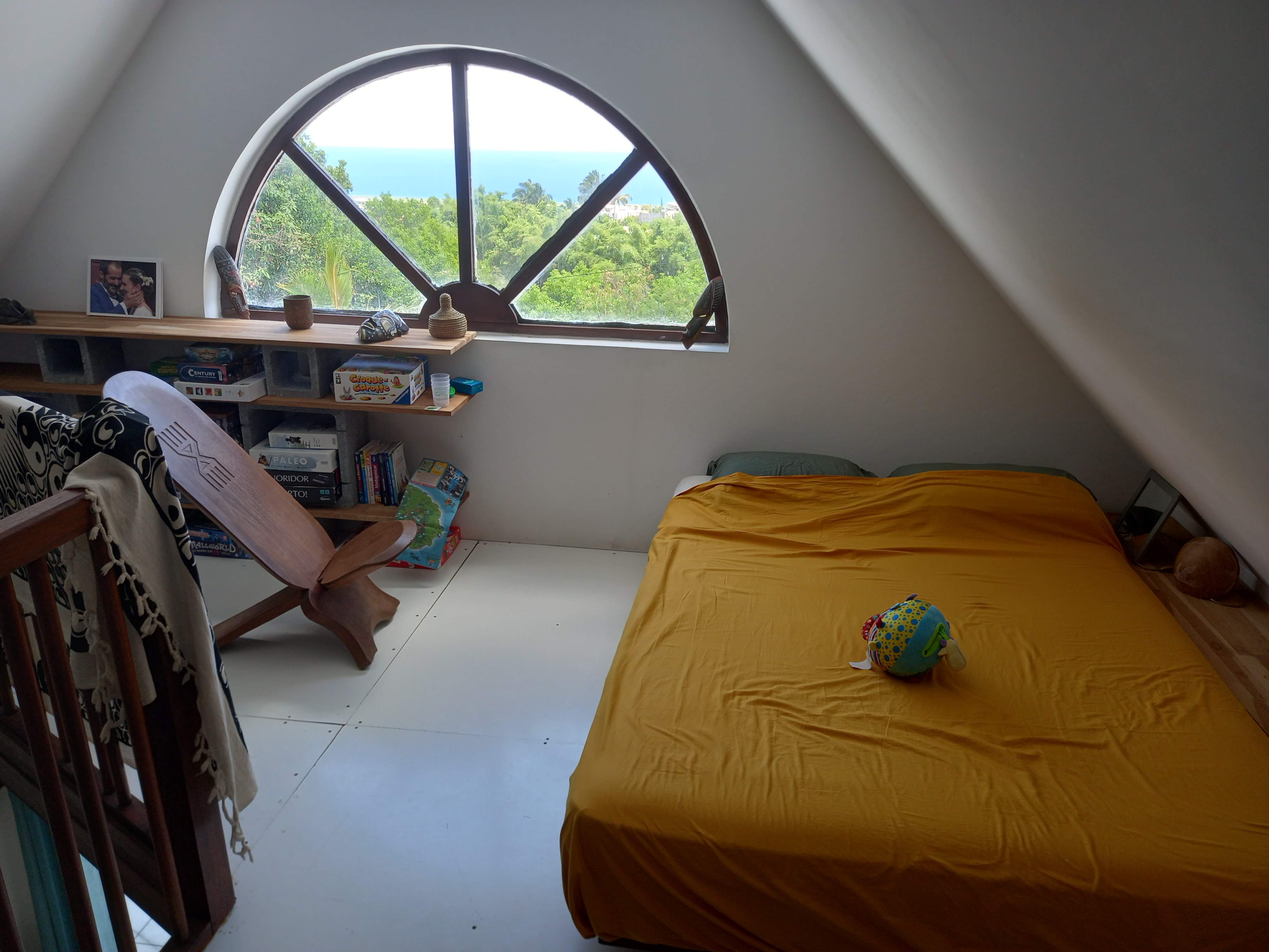 Mezzanine côté lit d'amis et étagères de jeux.